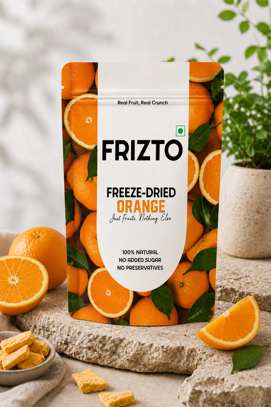 Packaging of Frizto freeze-dried orange with oranges and snacks on a natural background